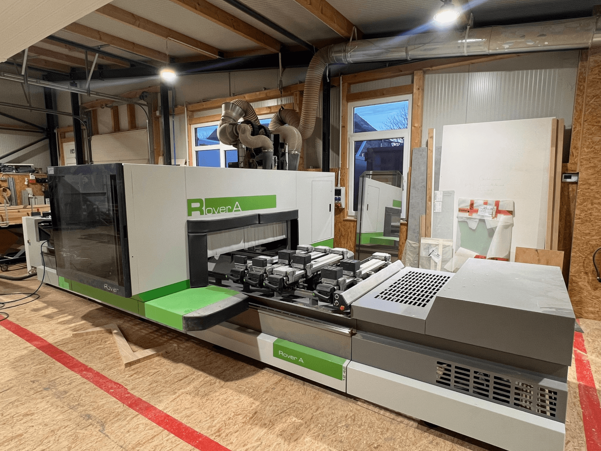 "BIESSE Rover A 1242" CNC medienos apdirbimo centras, priekinis vaizdas, kuriame matomas valdymo skydelis ir pjovimo zona dirbtuvėse.