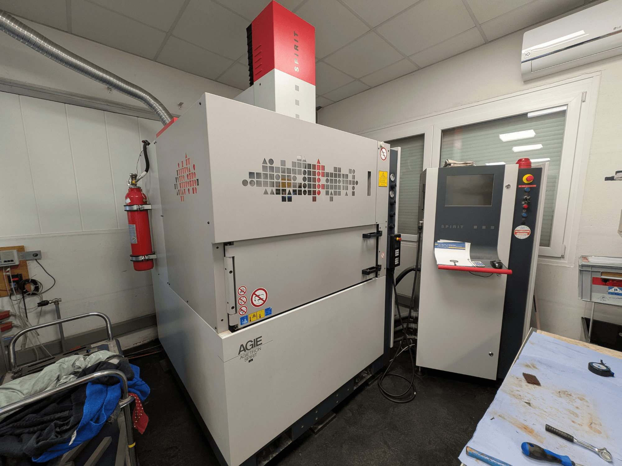 Šoninis vaizdas, kuriame matomas valdymo skydelis ir gesintuvas.