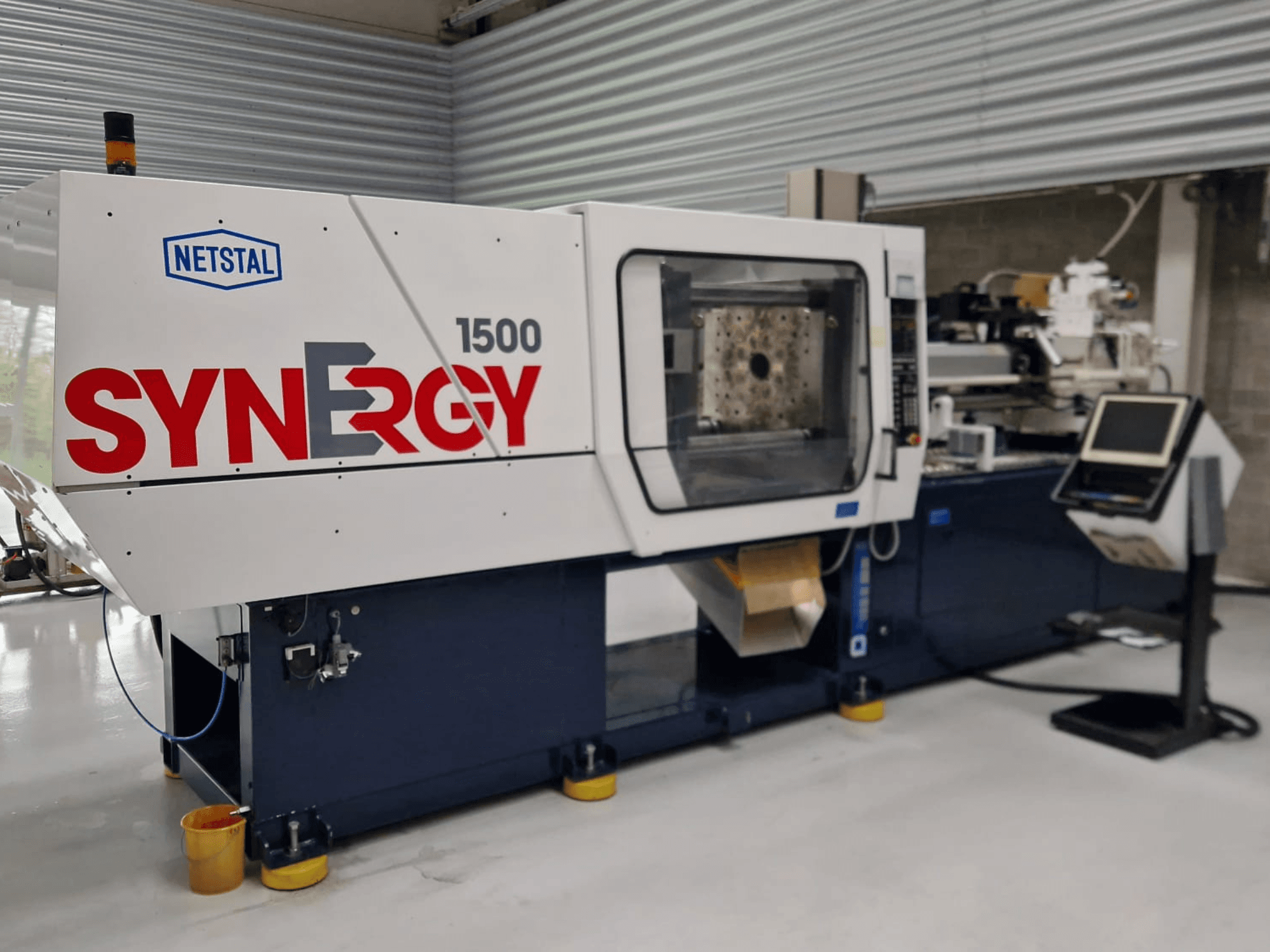 Netstal Synergy 1500-460 hidraulinė įpurškimo mašina, vaizdas iš priekio, valdymo skydelis ir atvira įpurškimo zona.