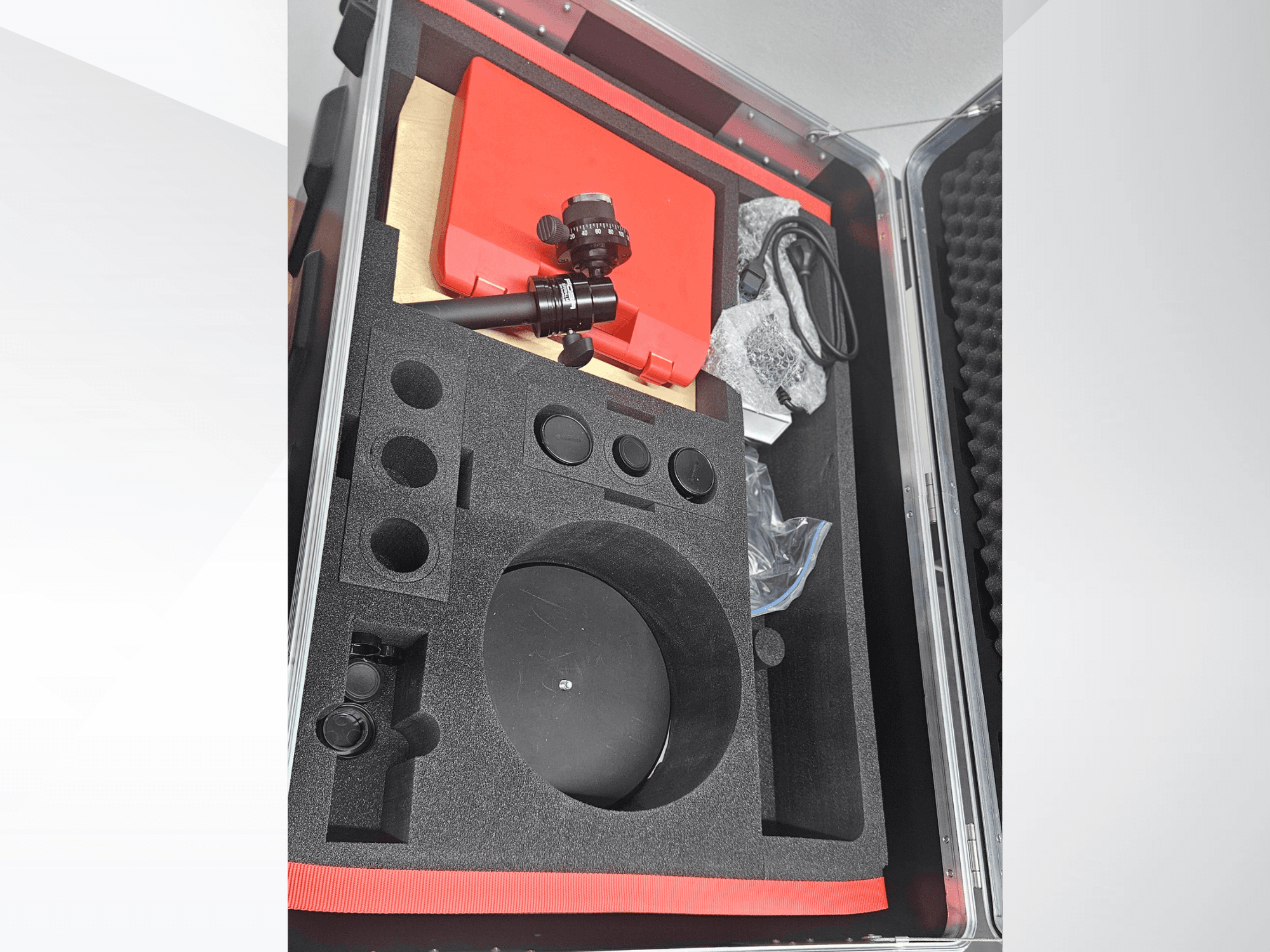 "ZEISS GOM ATOS 5" optinio matavimo aparato komponentai putplasčiu išklotame dėkle su objektyvu, priedais ir apsaugine pakuote.