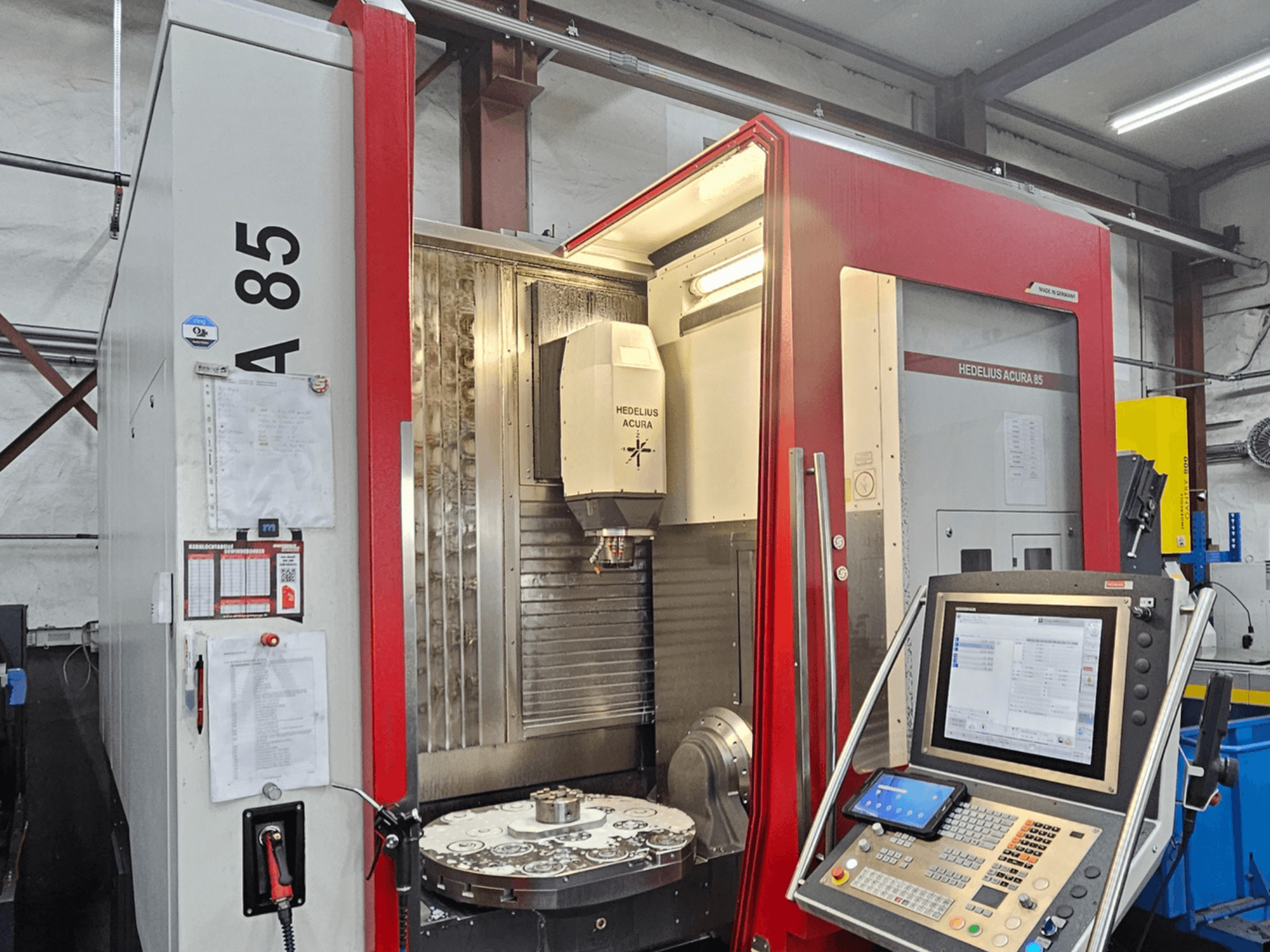 HEDLIUS Acura 85 vertikalusis apdirbimo centras, vaizdas iš priekio, su valdymo pultu ir sukamuoju stalu, skirtu tiksliam apdirbimui.