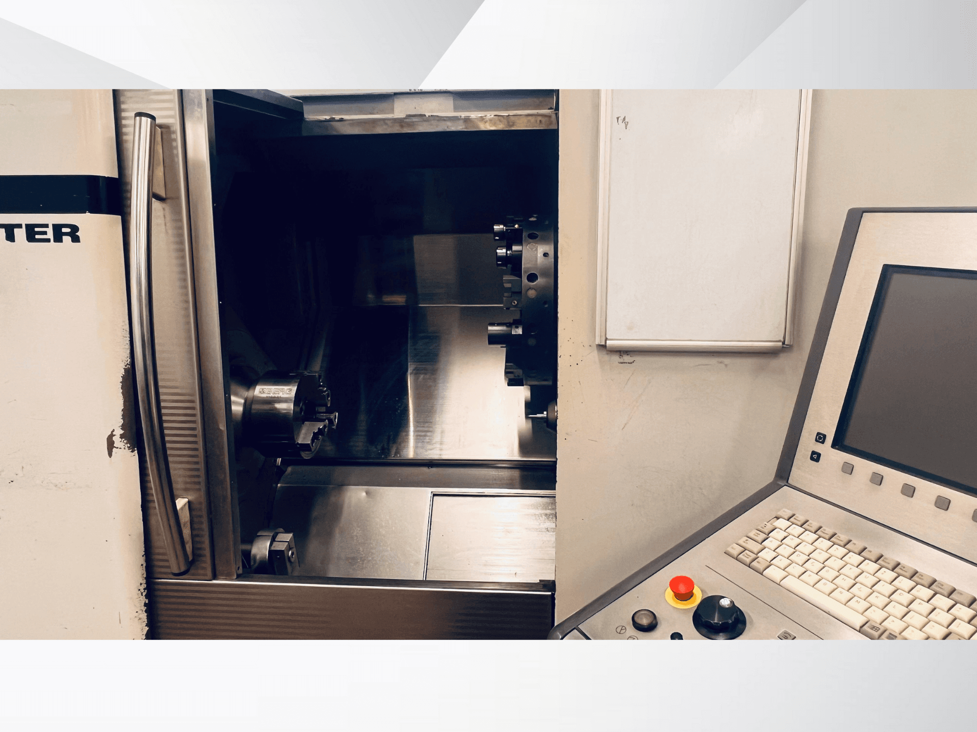 CNC staklių priekinis vaizdas, rodantis atvirą kamerą ir valdymo skydelį su klaviatūra ir avarinio stabdymo mygtuku.