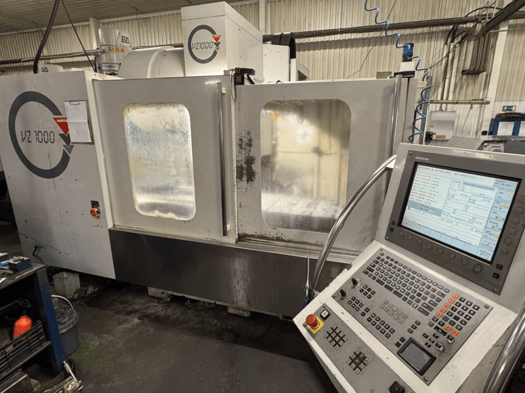 Vertikalaus apdirbimo centro WEMAS VZ 1000 su valdymo pultu ir permatomomis prieigos durelėmis vaizdas iš priekio.