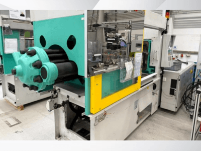 Šviesiai mėlynos ir geltonos spalvos įpurškimo liejimo mašina, vaizdas iš priekio, matoma forma ir valdymo skydelis su etiketėmis.