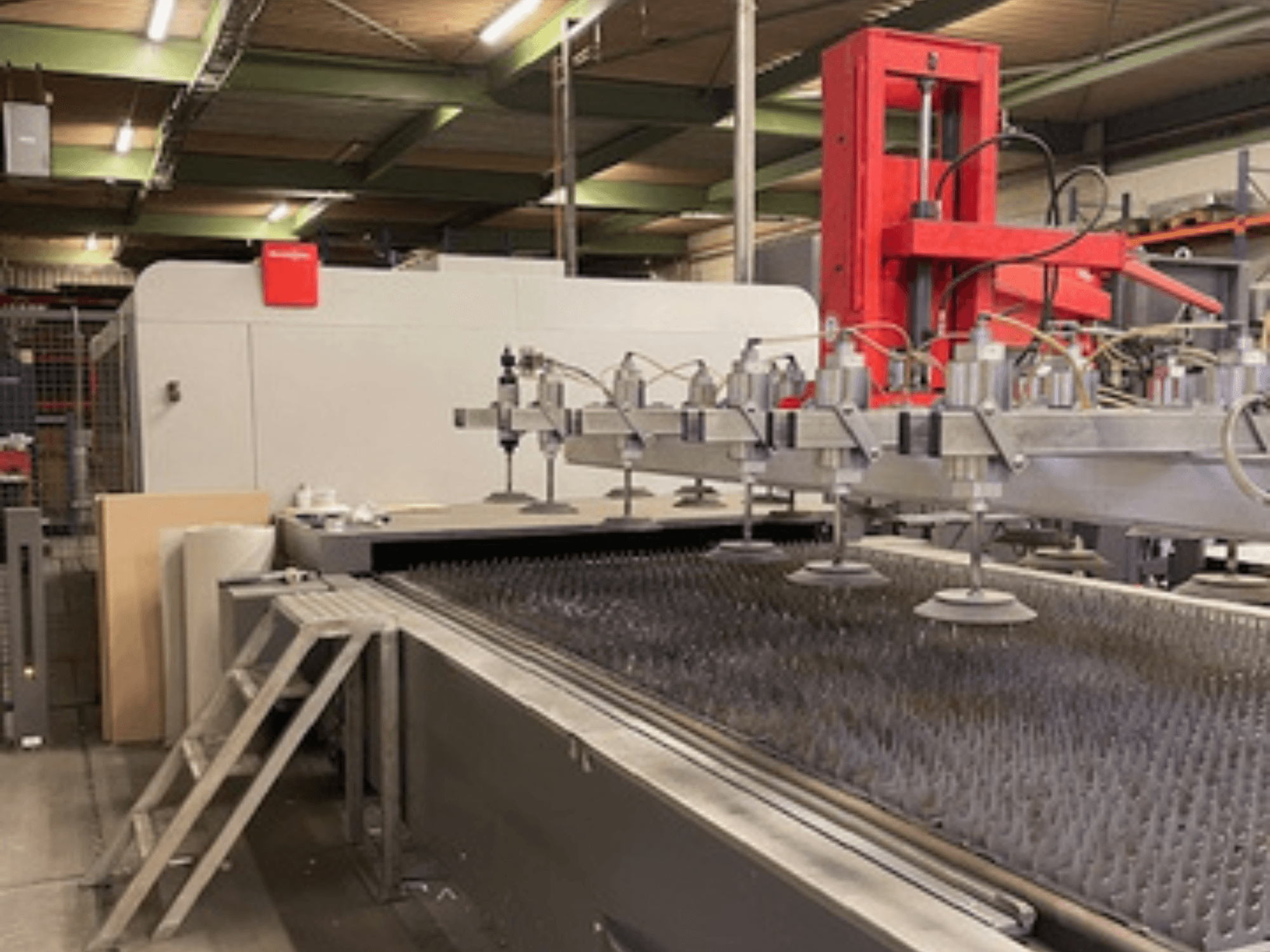 "Bystronic BySprint Fiber 4020 Fiber 4Kw" pluoštinio lazerinio pjovimo mašinos vaizdas iš priekio su purkštukais ir pjovimo lova.