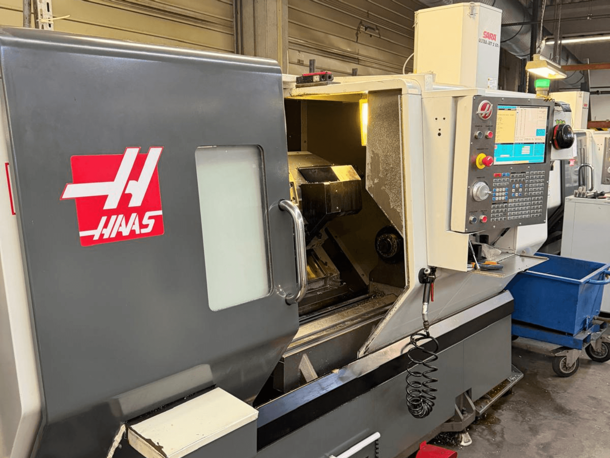 HAAS DS-30SSY horizontalios tekinimo staklės, vaizdas iš priekio, matomas valdymo skydelis ir vidiniai komponentai, dirbtuvėse.