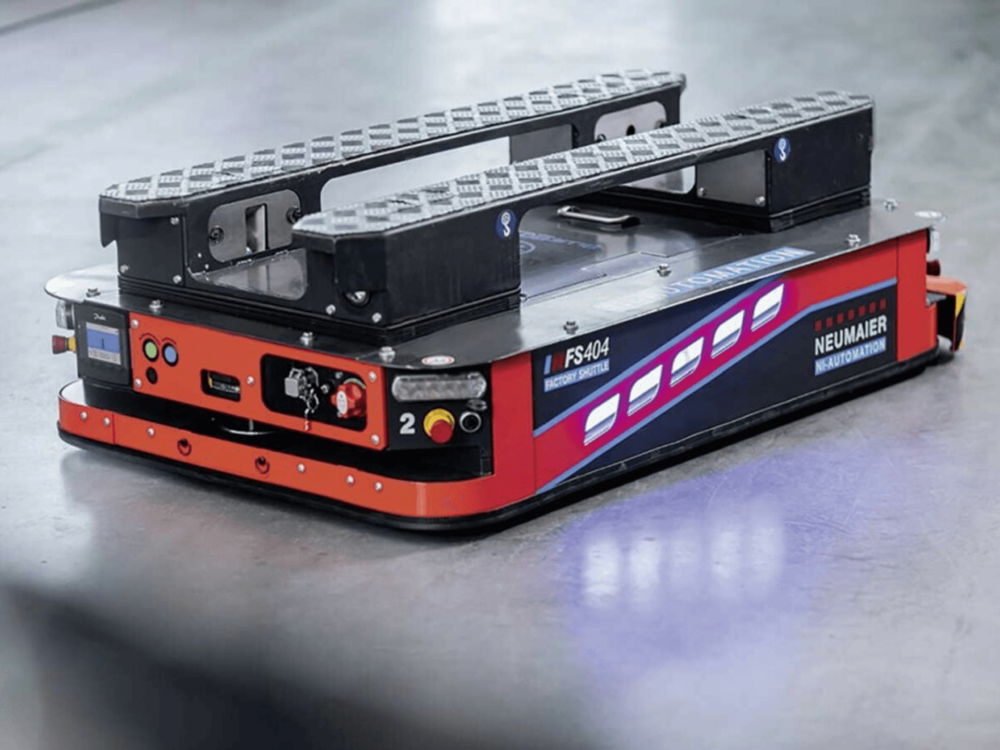 NEUMAIER AGV Factory Shuttle FS404, žemo profilio padėklų tvarkymo sistema, šoninis vaizdas, kuriame matomi ratai, valdikliai ir saugos elementai.