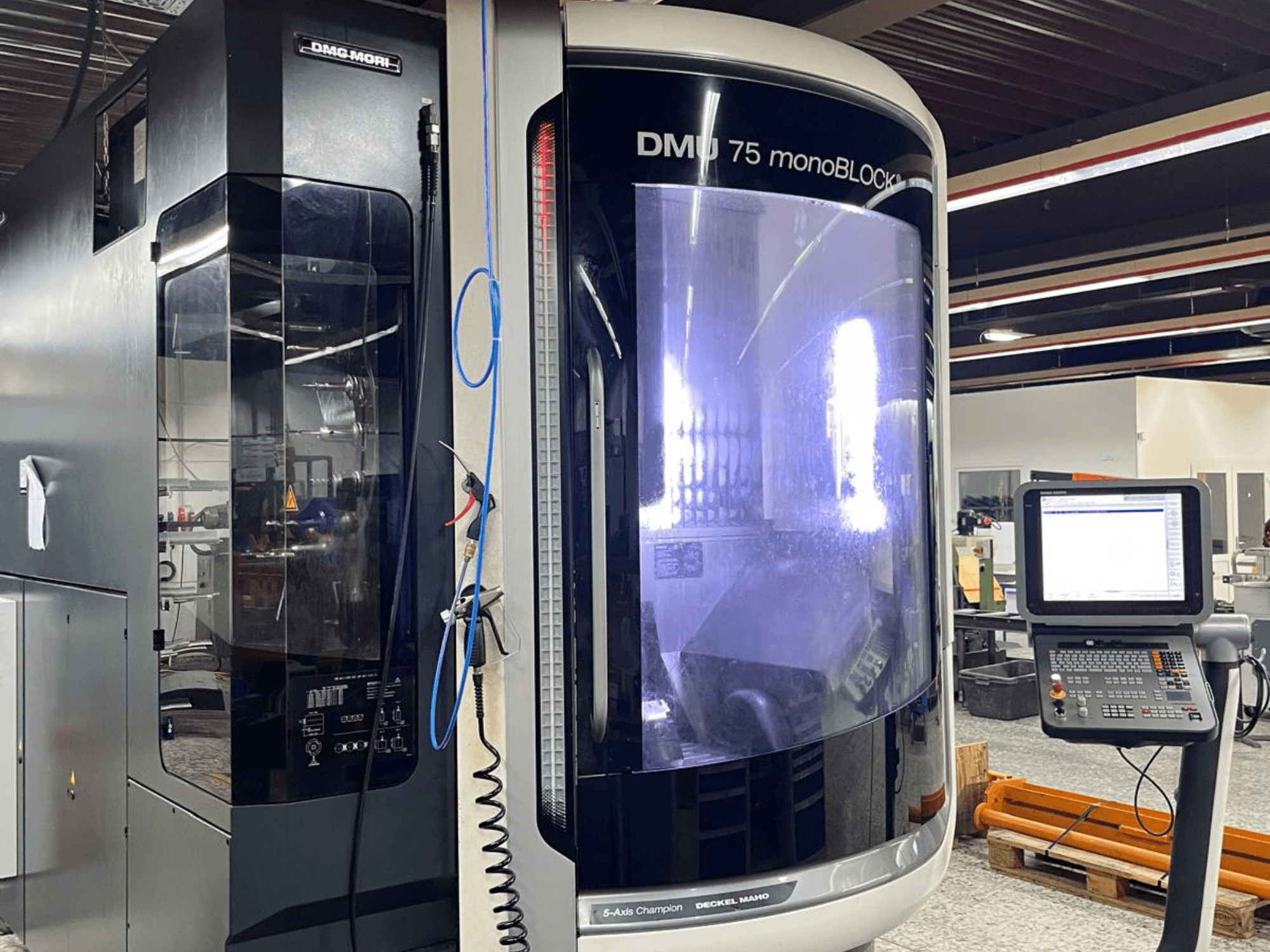 DMG MORI DMU 75 MonoBlock universalus apdirbimo centras, vaizdas iš priekio, matomas valdymo skydelis ir išskirtinis korpusas.