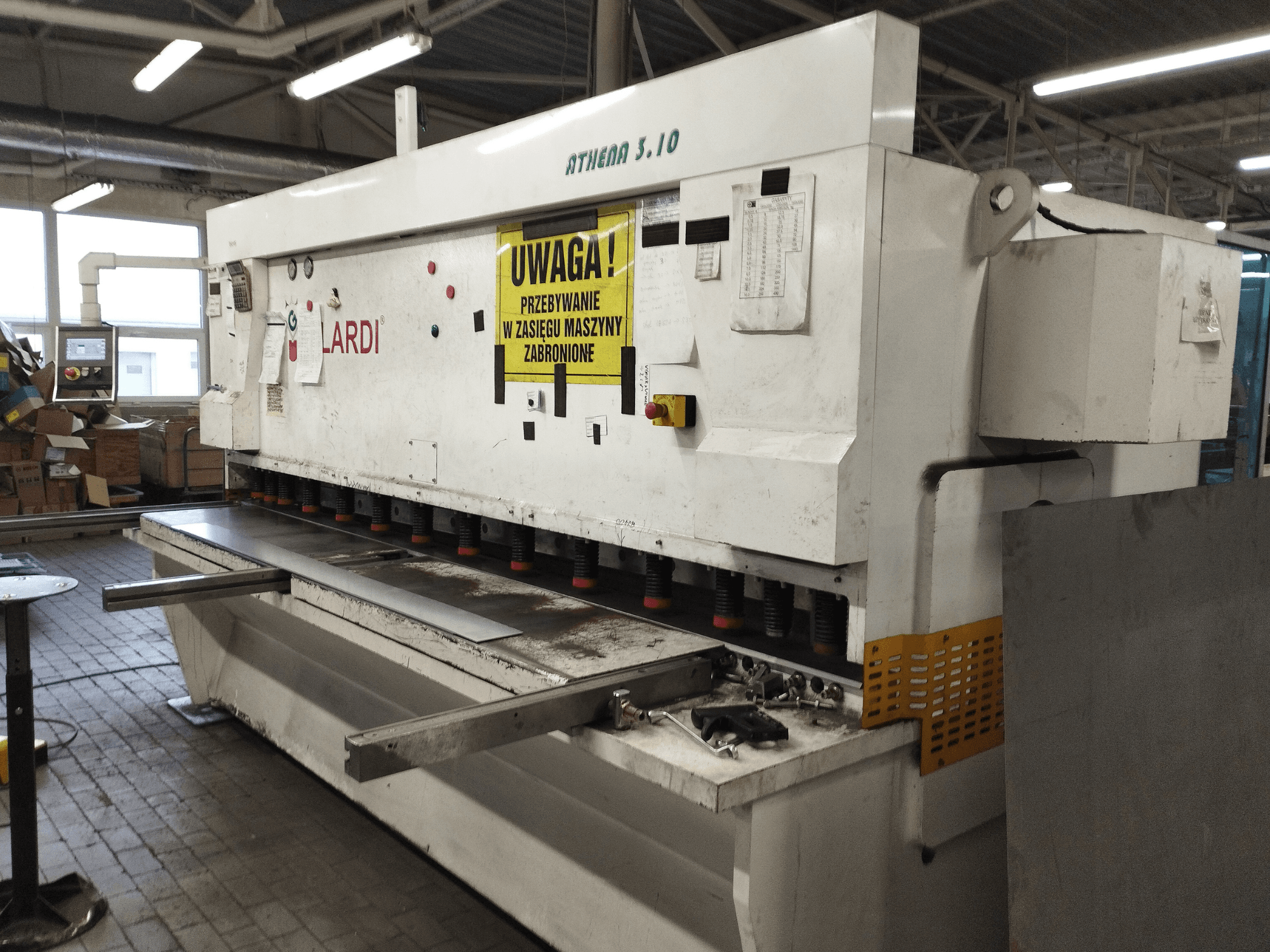 GILARDI ATHENA 3.10 CNC pjovimo staklės dirbtuvėse, vaizdas iš priekio, kuriame matomas valdymo pultas ir pjovimo peiliai.
