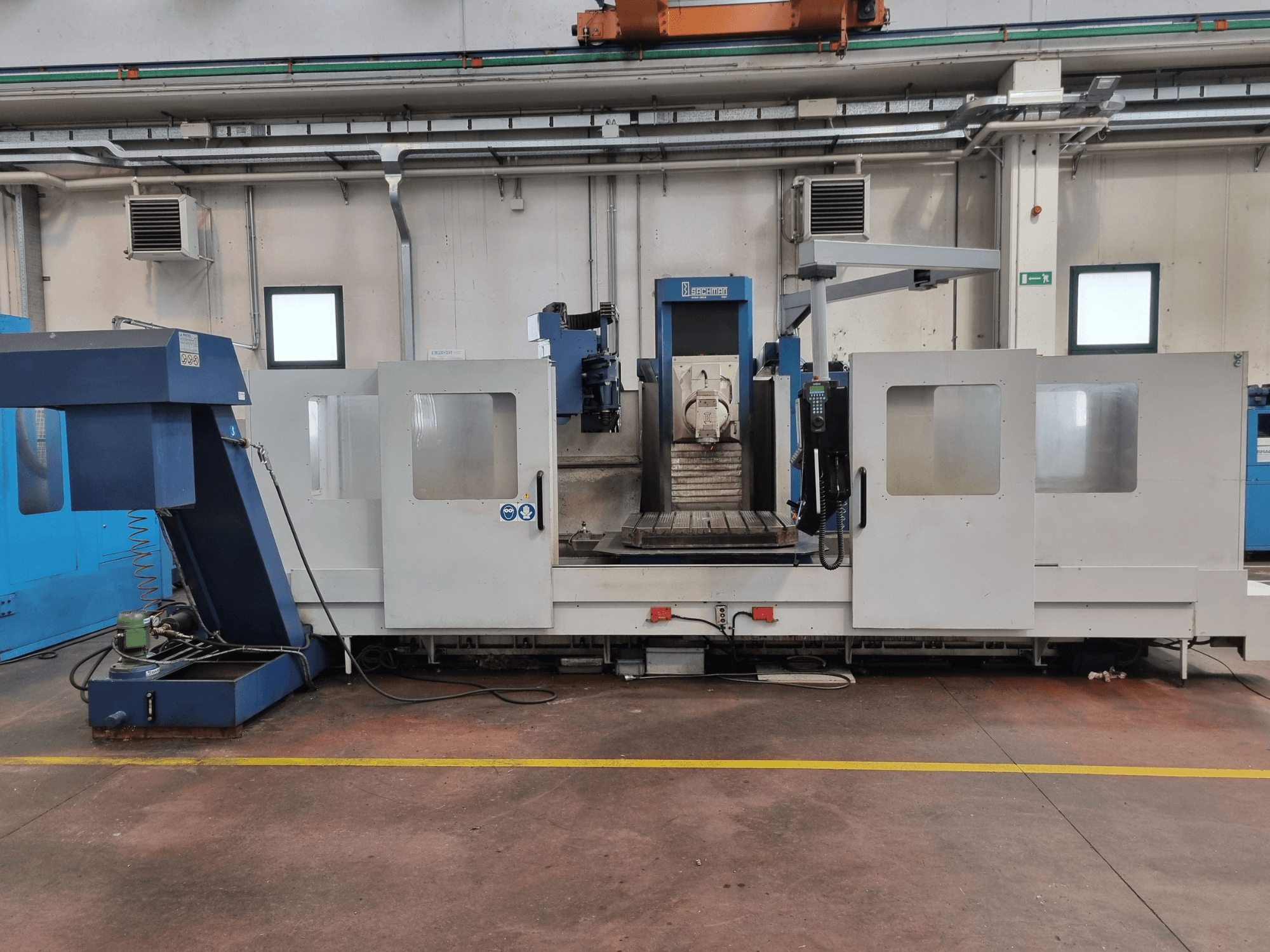 "Brembana" CNC frezavimo staklės, šoninis vaizdas, rodantis valdymo skydelį ir darbo zoną su viduje esančiu darbo stalu.