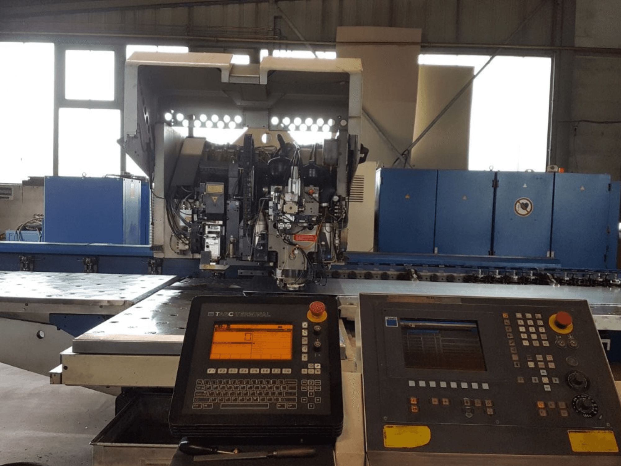 TRUMPF Trumatic 600L perforatoriaus ir lazerio derinys, vaizdas iš priekio, kuriame matomas valdymo skydelis ir mašinos detalės dirbtuvėse.