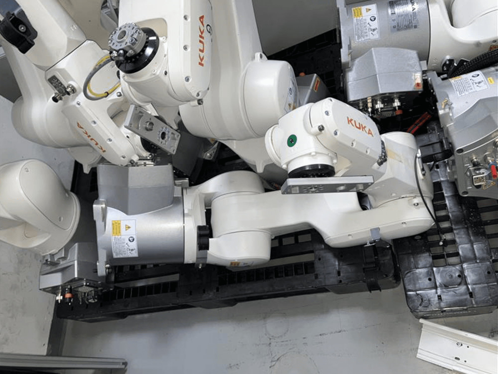 KUKA KR 10 R900-2 roboto ranka, žiūrint iš viršaus, demonstruojanti šarnyrinius sąnarius ir pavaros variklius pramoninėje aplinkoje.