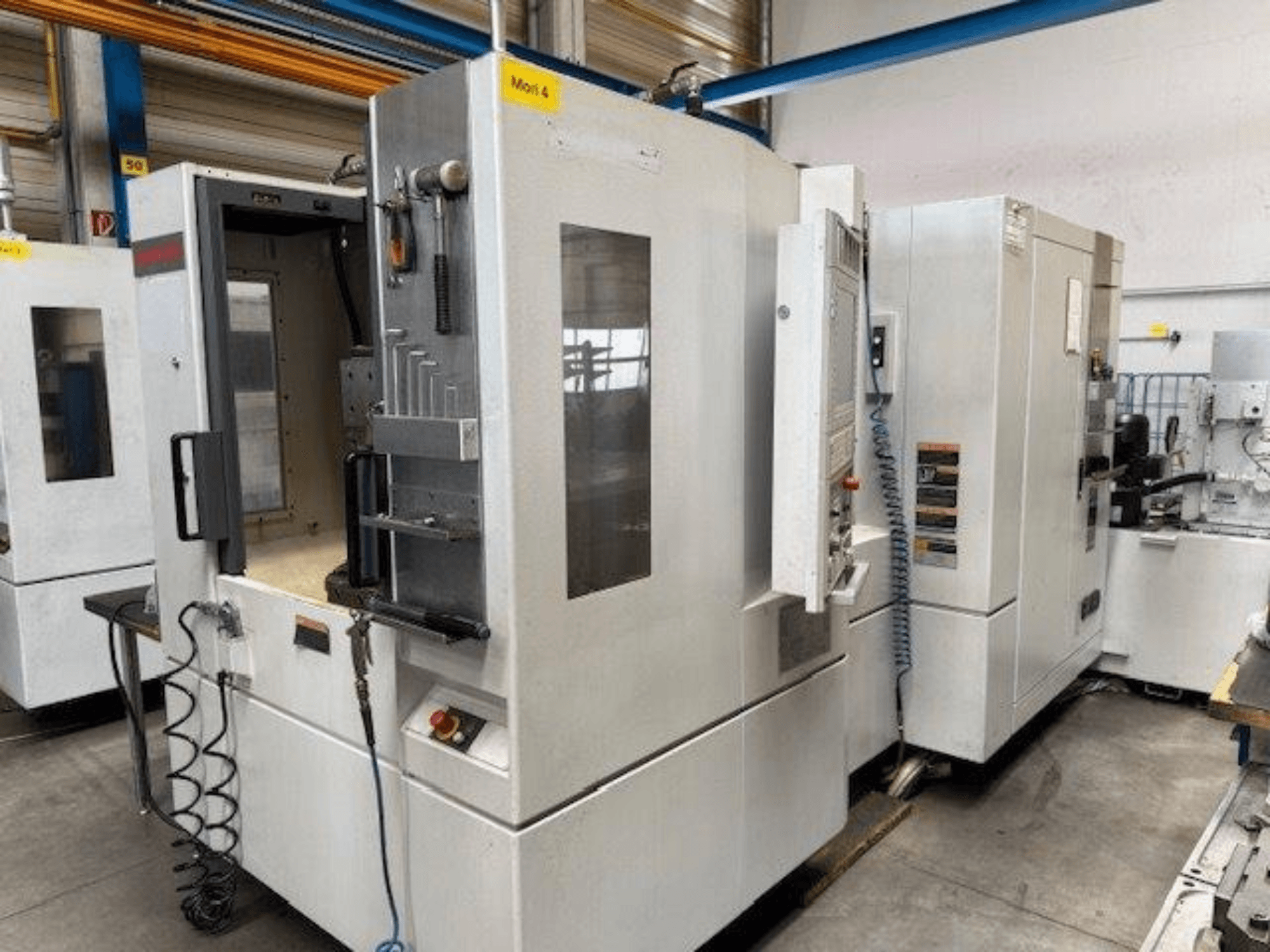 MORI SEIKI NH4000 DCG horizontalusis apdirbimo centras iš priekio, su atviromis durelėmis ir valdymo skydelio detalėmis.