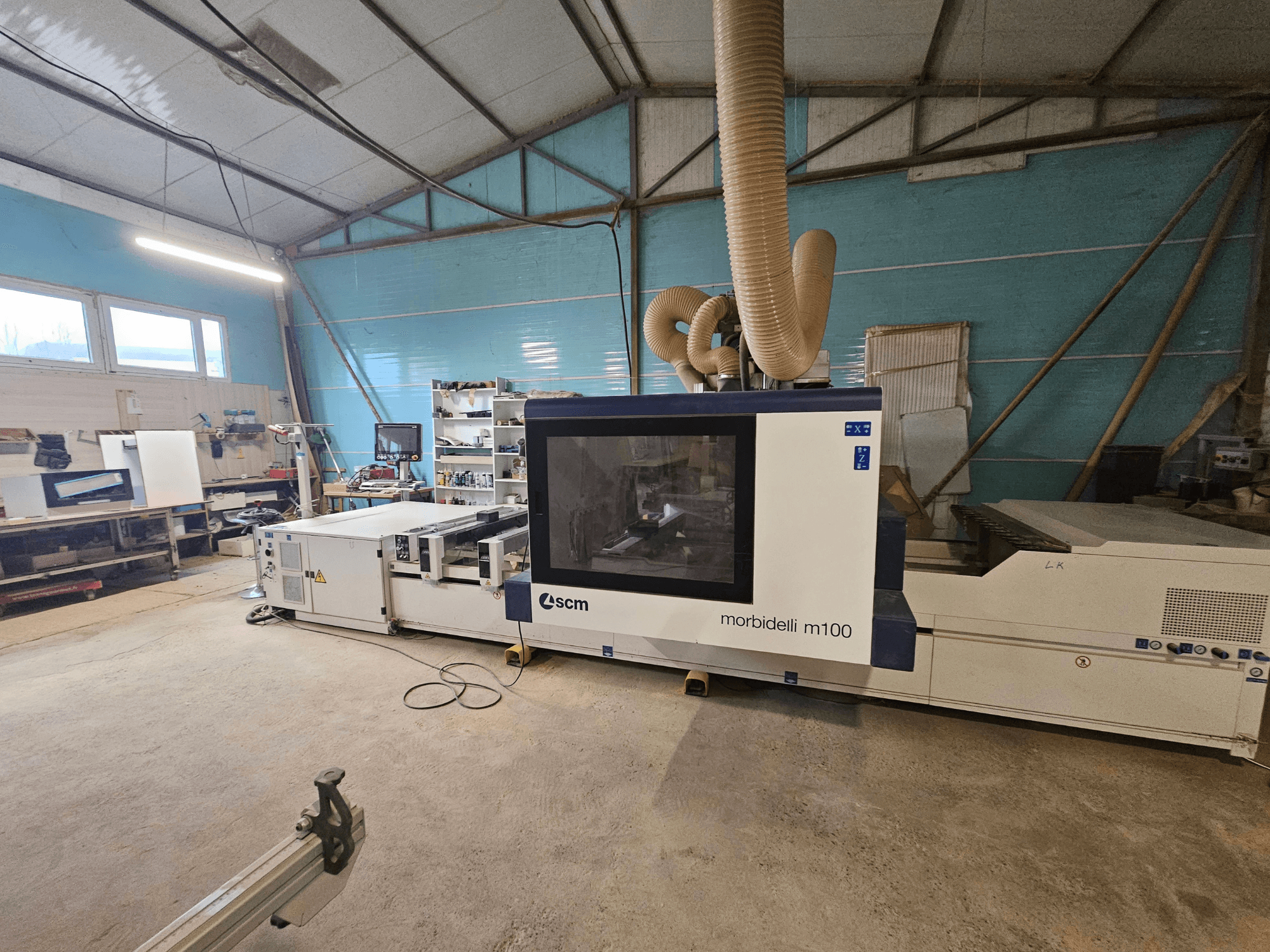 SCM Morbidelli M100 CNC staklės dirbtuvėse, vaizdas iš priekio, dulkių ištraukimo sistema ir valdymo skydelis.
