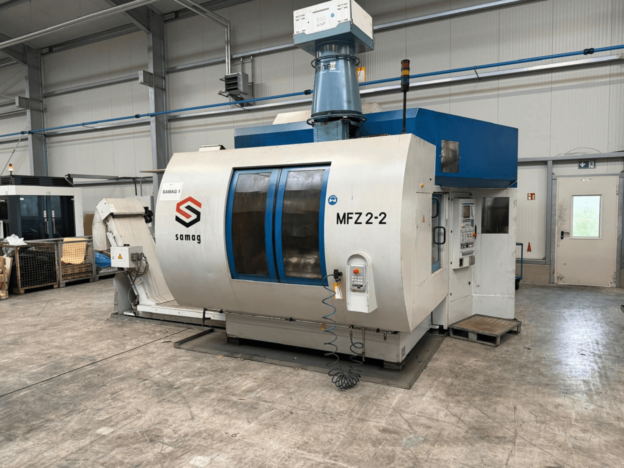 Samag MFZ 2-2 staklės, vaizdas iš priekio, matomas valdymo skydelis ir mėlynas viršus, su saugos funkcijomis pramoninėje aplinkoje.