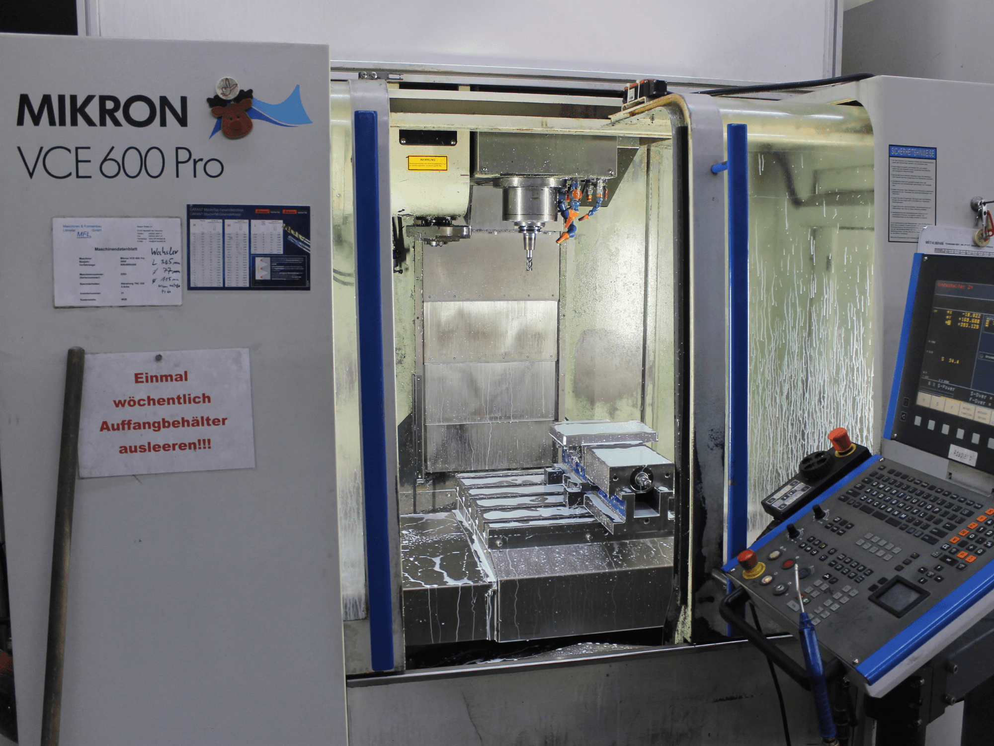 "Mikron VCE 600 Pro" apdirbimo centras, vaizdas iš priekio, pjovimo įrankiai, aušinimo skysčio purkštuvas ir valdymo skydelis su mygtukais.