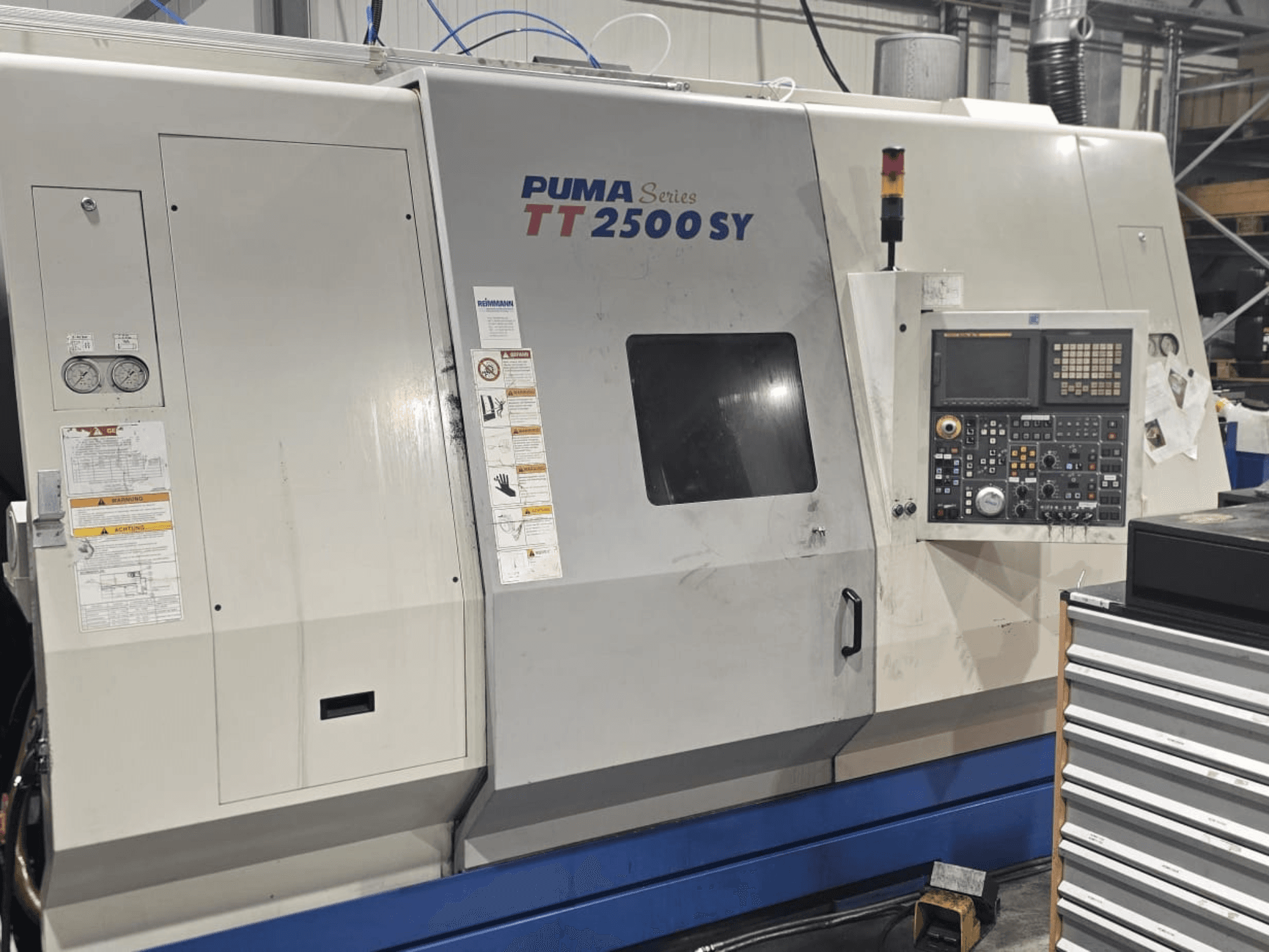PUMA serijos TT 2500 SY CNC tekinimo staklės, vaizdas iš priekio; matomas valdymo skydelis su ciferblatais ir mygtukais, matuokliais ir veikimo etiketėmis.