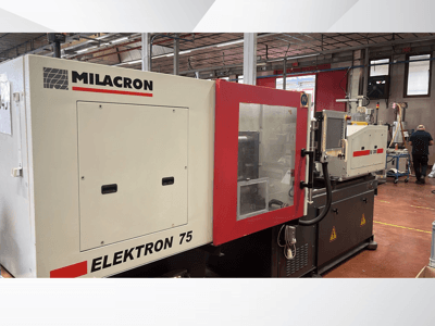"Milacron Elektron 75" įpurškimo liejimo mašina dirbtuvėse, šoninis vaizdas, kuriame matomas valdymo skydelis ir mechaninės dalys.
