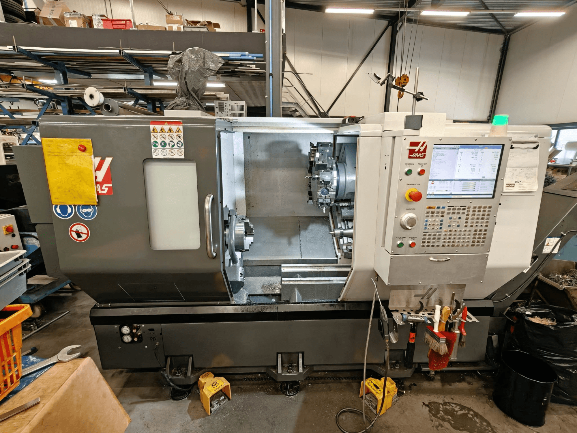 HAAS ST-25Y horizontalios tekinimo staklės, vaizdas iš priekio, kuriame matomas valdymo skydelis, įrankių laikymo vieta ir darbinė sąranka dirbtuvėse.