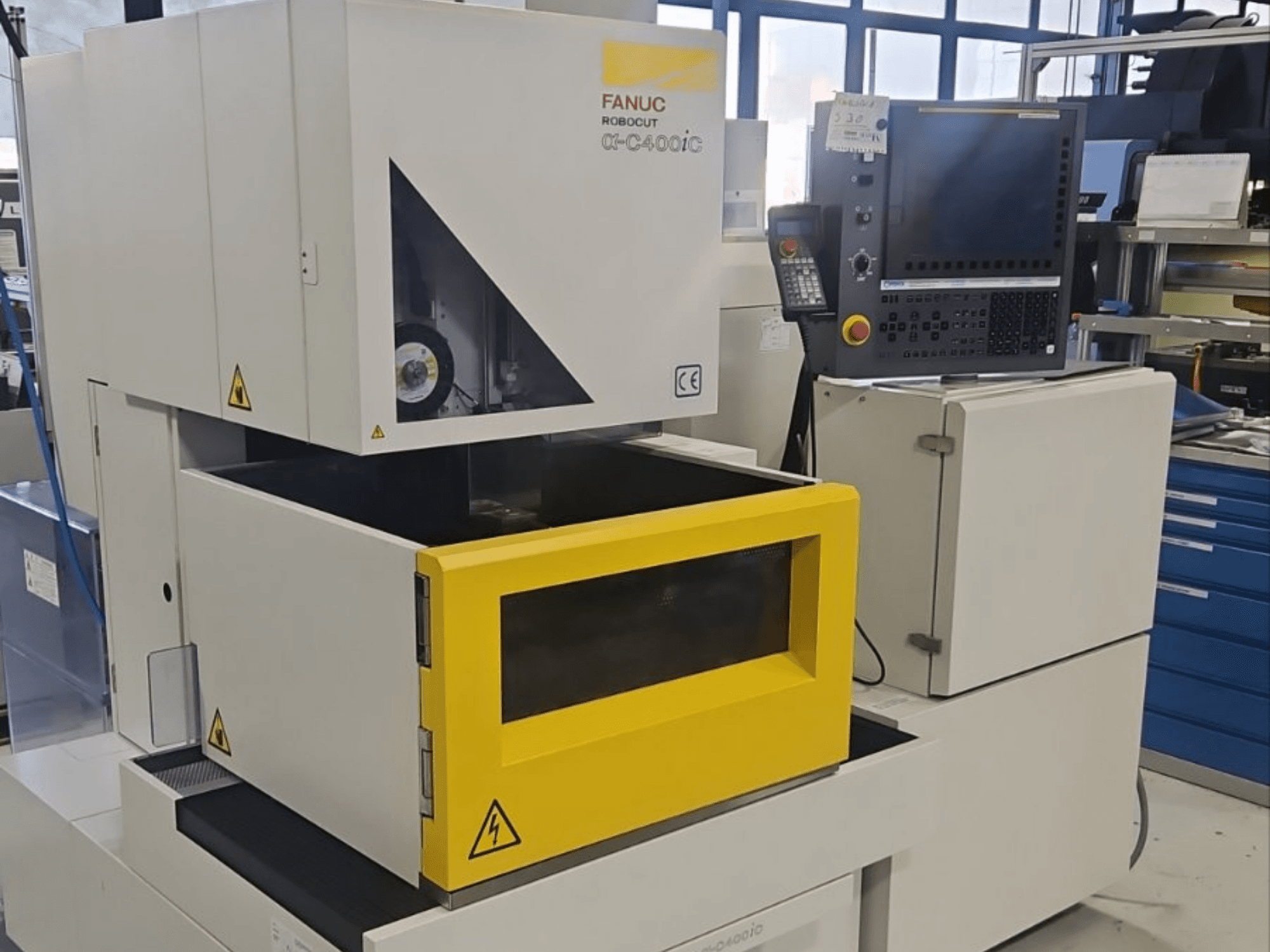 „FANUC Robocut alpha-C400iC“ giluminio išpjaustymo EDM staklės, vaizdas iš priekio, su geltona ruošinio kamera ir valdymo skydeliu.
