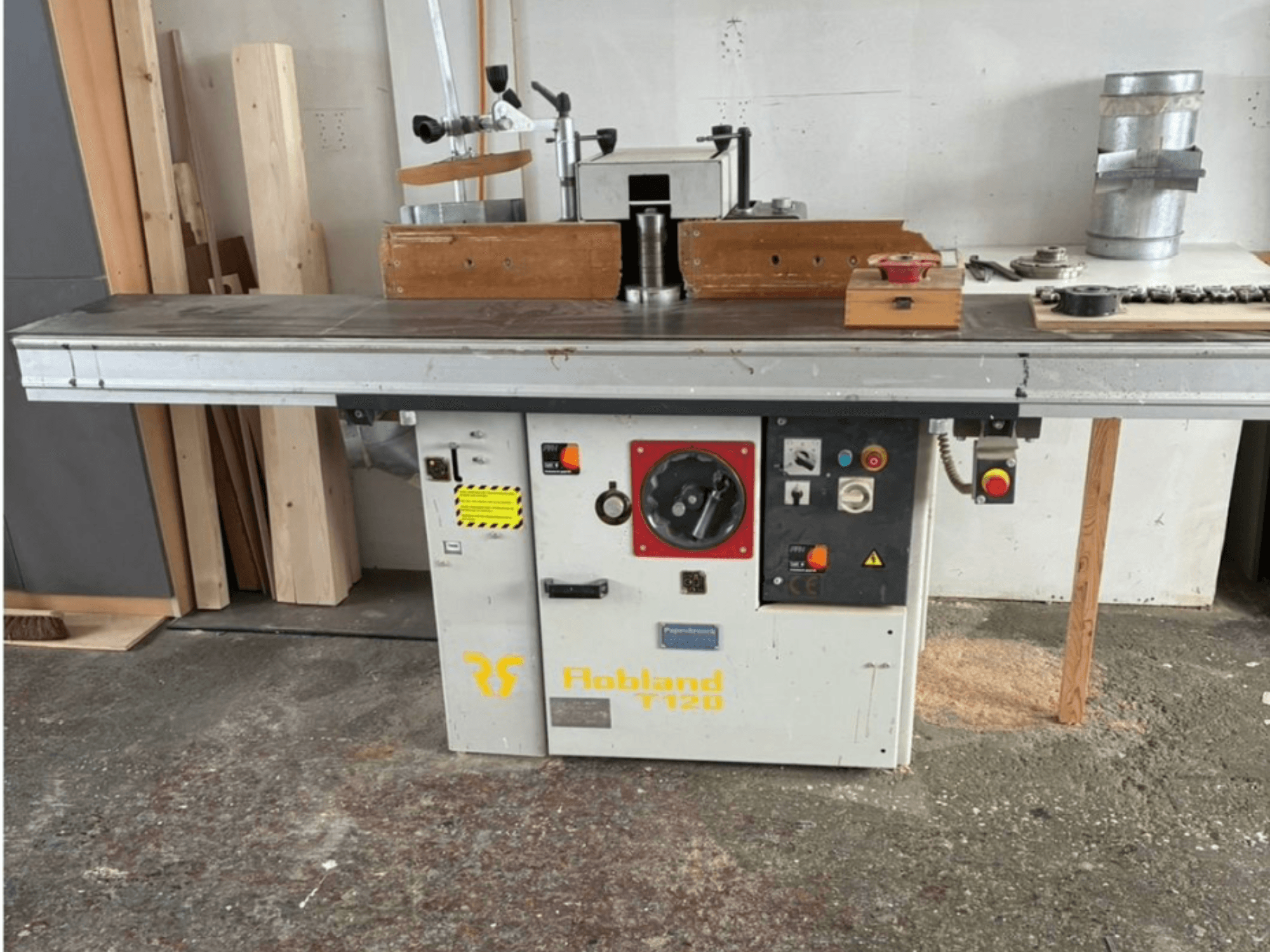 Stalo obliavimo staklės "Hobbland T120", vaizdas iš priekio, su sidabriniu paviršiumi, valdymo skydeliu su mygtukais ir saugos etiketėmis.