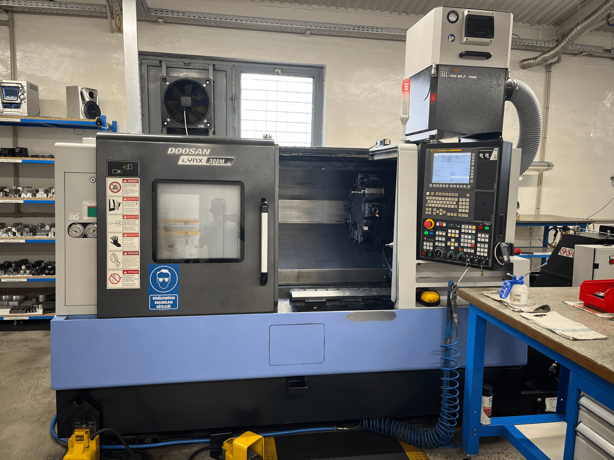 „DOOSAN LYNX 300M“ horizontalioji tekinimo staklė, vaizdas iš priekio, kuriame matomas valdymo pultas ir darbo elementai.